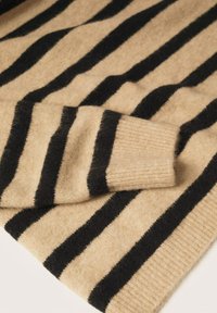 Beige wollen trui met zwarte strepen, voorzien van een geribde manchette en een zachte textuur. Het ontwerp benadrukt het contrast in kleur en patroon.