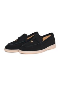 Black loafers with a smooth fabric upper, featuring a decorative strap and gold-tone hardware, set on a beige rubber sole.