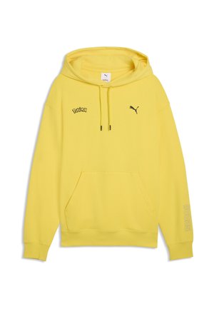 Gul hættetrøje med frontlomme, sort Puma-logo på højre bryst, Pokémon-logo på venstre bryst og "#0025" på venstre ærme.