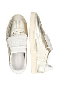 Sneakers slip-on metallic oro con cuciture bianche, suola bianca e cinturino bianco con il marchio MNH in rilievo.