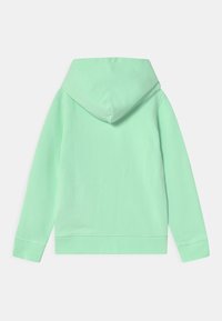 Miętowa bluza z kapturem, z kieszenią kangurką, dużym kapturem i ściągaczami na rękawach. Gładka faktura i swobodny fason, bez widocznych logo czy wzorów.