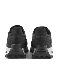 Scarpe sportive nere in suede con parte superiore testurizzata, intersuola bianca a contrasto e suola in gomma nera con battistrada prominente per una buona aderenza.