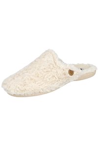 Zapatilla de casa fuzzy color crema con textura suave, punta redondeada y suela marrón. Presenta un pequeño logo en el lateral. Ideal para la comodidad.