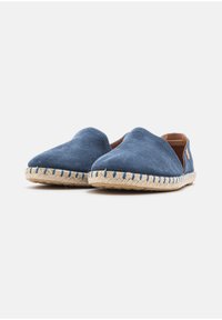 Blue suede slip-on shoes with a rounded toe and woven jute sole. Features tan accents on the heel and contrasting blue stitching.