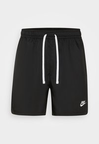 Svarta badshorts i lätt material med en vit dragsko och en liten vit Nike-logotyp på nedre högra sidan.