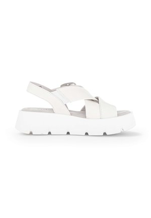 Witte platformsandaal met dikke zool en brede gekruiste banden, voorzien van een achterriem met verstelbare gesp sluiting.