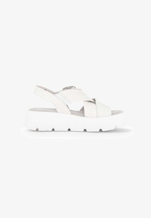 White platform sandal with thick sole and wide crisscross straps, featuring a back strap with adjustable buckle closure.