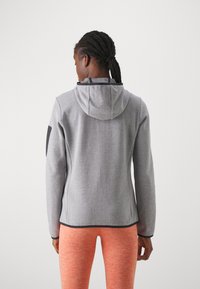 Gray hoodie with a textured fabric, a hood, and black accents. It has a fitted design and is paired with orange, heathered leggings.
