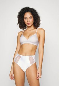 Lavender bralette with thin straps paired with high-waisted white panties featuring sheer side panels and floral embroidery accents.