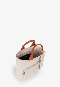Borsa tote beige con manici in pelle marrone, tasca frontale con zip e un'etichetta in tessuto con la scritta "UNA BORSA RESPONSABILE."