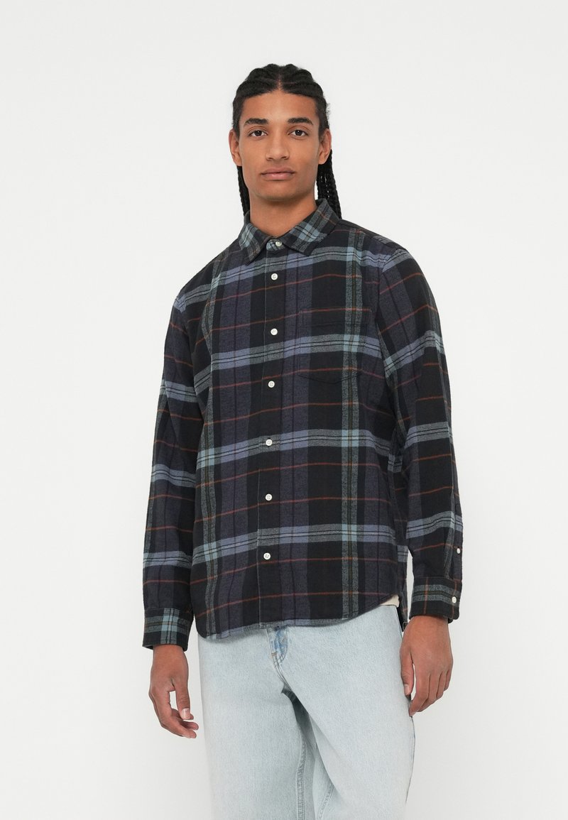 Sort og blåternet flannelsskjorte med button-down krave, lange ærmer og hvide knapper. Blød tekstur med kontrasterende mønstre.