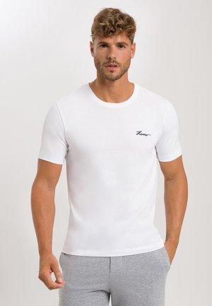 Hvid crew-neck t-shirt lavet af glat, let stof; har et sort broderet logo på brystet. Tætsiddende korte ærmer.