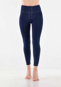 Leggings blu scuro a vita alta realizzati in denim elasticizzato. Presentano cuciture verticali e una zip sul davanti. Texture morbida con un design aderente.