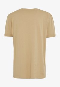 Camiseta de algodón beige con cuello redondo, mangas cortas y un corte relajado. La tela tiene una textura suave con un acabado liso.