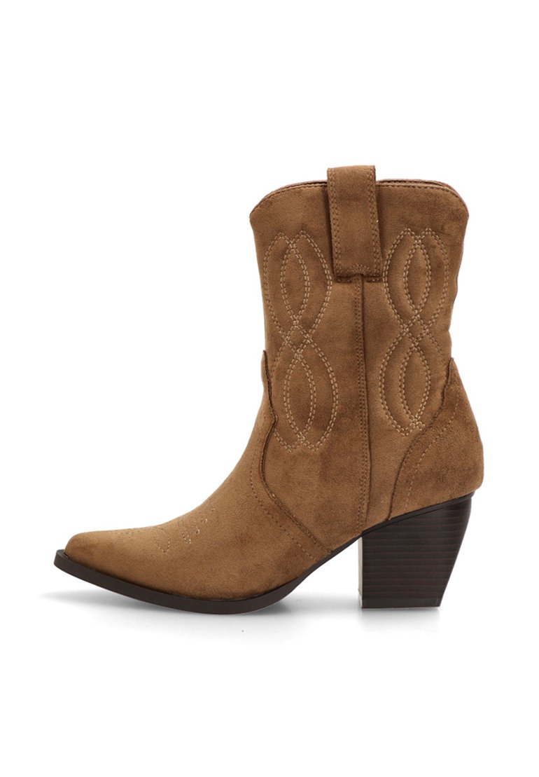 Botín de ante marrón estilo western hasta el tobillo con punta afilada, costuras decorativas y un tacón cuadrado. Presenta una lengüeta en la parte trasera.