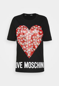 Black t-shirt featuring a large red heart graphic with white floral patterns and the text "LOVE MOSCHINO" in bold white letters at the bottom.