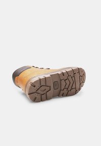 Tume ja pruuni matkajalats, mis on külili, näidates tekstuuriga tallaga, mille keskel on märgitud suurus 27.