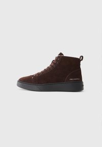 Brune ankelhøye sneakers i semsket skinn med snøring, gummisåle og en løfteskatt bak. Har merkevarelogo på siden.