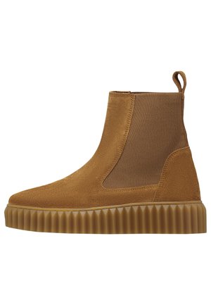 Stivaletto in camoscio marrone con pannello laterale elastico, linguetta posteriore e suola in gomma rigata.