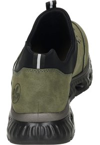 Chaussure en daim verte à enfiler avec un col en tissu noir, des rayures blanches et une semelle en caoutchouc noir texturée dotée de trous de ventilation.