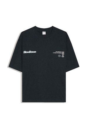 Schwarzes kurzärmeliges T-Shirt mit weißem Text "SlowDown" auf der linken Seite und "THE BRIGHT HAZE A PUSH OF GOOD VIBES 2026" auf der rechten Brust.