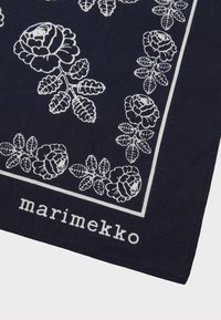 Marineblå bomullssjal med hvitt blomsterdesign med roser og blader, avgrenset av en hvit linje. Merkevaren "marimekko" er vist.