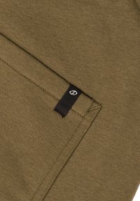 Olijfgroen stof met een gladde textuur en een gevouwen ontwerp. Heeft een zwarte tag met een logo aan de rand.