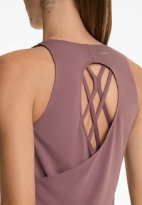 Mauve atletski top s ključnom rupom na leđima i križnim trakama, glatke teksture, s logotipom u obliku petlje na izrezu.
