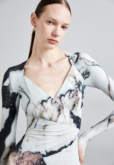 Long-sleeve dress in stretchy fabric features a marbled pattern in white, black, and beige. V-neck design with wrapped torso detail.