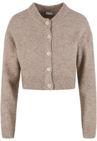 Īss bēšs kardigans no mīksta trikotāžas auduma ar ribotu apakšu, apaļu apkakli un sešām gaismas krāsas pogām priekšpusē.