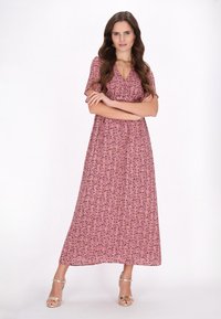 Roze bloemenmaxijurk met korte fladdermouwen, met een fitted lijfje, een losse geplooide rok en subtiele zwarte en groene accenten.
