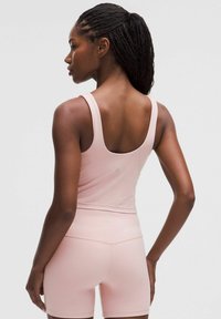 Lys pink atletisk tanktop med scoop ryg og matchende tætsiddende shorts, lavet af glat, strækbart stof, der fremhæver et sømløst design.