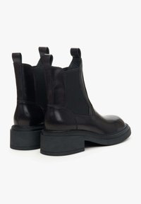 Czarne skórzane botki za kostkę z elastycznymi panelami po bokach, okrągłym noskiem i niskim obcasem w kształcie bloku, z subtelnym przeszyciem i gładkim wykończeniem.