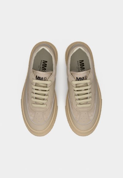 Ζευγάρι μπεζ χαμηλά sneakers MM6 Maison Margiela με παχύ, υφασμένο πέλμα και κορδόνια, σε θέα από πάνω πάνω σε λευκό φόντο.