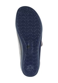 Sole of a shoe featuring a textured, dark navy rubber material with a herringbone pattern and a circular logo at the bottom.