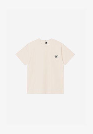 Μπεζ κοντομάνικο μπλουζάκι με λαιμόκοψη, με μικρό μαύρο κυκλικό λογότυπο που απεικονίζει πατημασιά στη αριστερή πλευρά του στήθους.