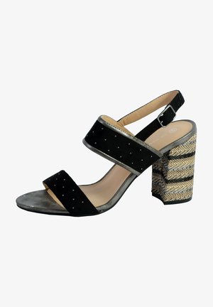 Sandale en suédine noire avec deux larges brides, des clous décoratifs, des accents argentés et un talon bloc à motifs en matériau tressé.