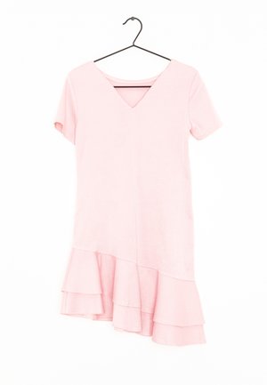 Jasnoróżowa, teksturowana sukienka z krótkim rękawem, dekoltem w serek i asymetrycznym falbankowym dołem, wisząca na czarnym wieszaku na ubrania na białym tle.