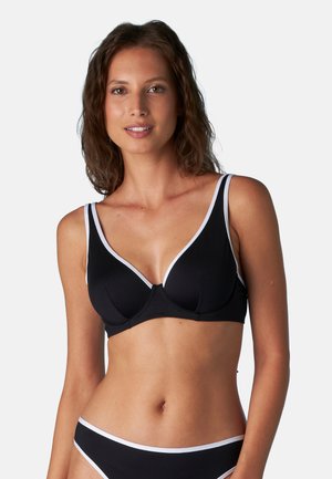 Reggiseno nero con bordi bianchi, caratterizzato da un design a V profonda, spalline regolabili e tessuto morbido e testurizzato. Adatto per l'uso quotidiano.