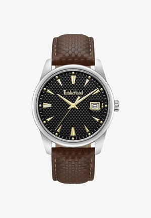 Timberland wristwatch with black textured dial, gold-tone markers and hands, date window at 3 o'clock, and brown textured leather strap.