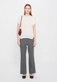 White short-sleeve top, gray and black striped wide-leg pants, and black flats; small burgundy bag with a shoulder strap.