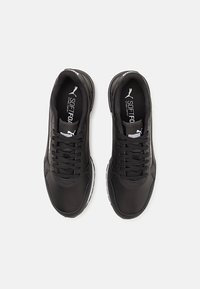 Czarne buty sportowe z gładką syntetyczną cholewką, okrągłym noskiem, tradycyjnym sznurowaniem i białymi akcentami na podeszwie. Posiadają logo marki na języku.