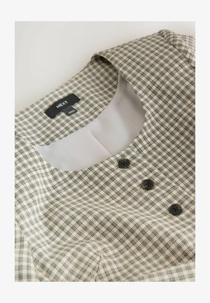 Kárované šaty v krémovej a čiernej farbe, s okrúhlym golierom, tromi čiernymi gombíkmi a hladkou vnútornou podšívkou pre pohodlie. Viditeľná značka výrobcu.