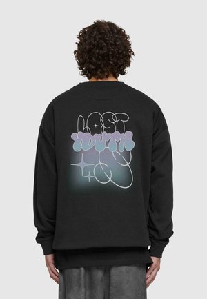 Sort sweatshirt med et stort grafisk motiv på ryggen, der har pastelfarvet "LAST YOUTH" tekst omgivet af abstrakte former og stjerner.