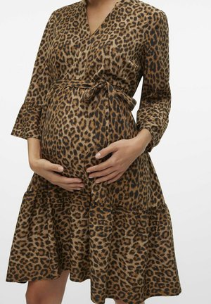 Vestido de maternidad con estampado de leopardo, que presenta un diseño cruzado, mangas largas y una falda con volantes. Confeccionado en una tela suave y con un cinturón en la cintura que acentúa la figura.