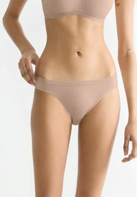 Beige nahtlose Bikini-Unterwäsche aus einem weichen, elastischen Stoff. Sie zeichnet sich durch eine tief sitzende Form und einen breiten elastischen Bund für Komfort aus.