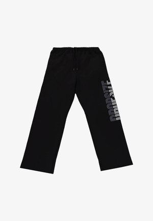 Black sweatpants with a loose fit, featuring a drawstring waist and a large silver logo text on the left side. Soft fabric with a smooth texture.