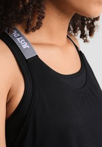 Černý sportovní tank top s kulatým výstřihem a širokými armholemi. Na ramenním pásku je šedý nápis "just do it". Hladká textilie.