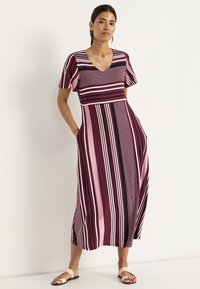 Gestreiftes Maxikleid mit V-Ausschnitt, kurzen Ärmeln, Taschen und einer Mischung aus dunkelroten, pinken und schwarzen Streifen in unterschiedlichen Breiten.