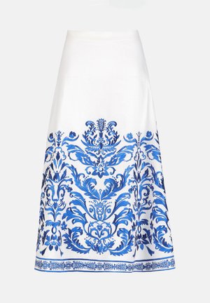 Jupe blanche trapèze avec une broderie bleue florale et ornementale complexe le long de la moitié inférieure et de l'ourlet.